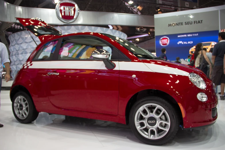 a small red compact car is on display