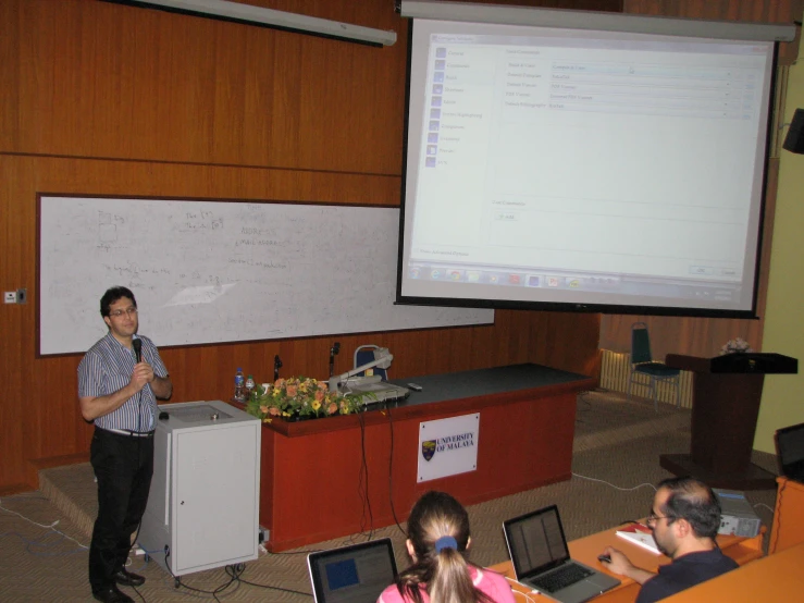 a man standing at the podium presenting a lecture