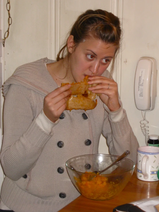 the girl is holding onto her sandwich to eat it