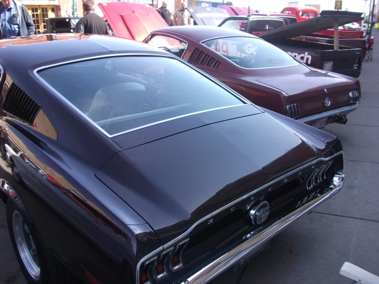 the front of two vintage mustangs parked side by side