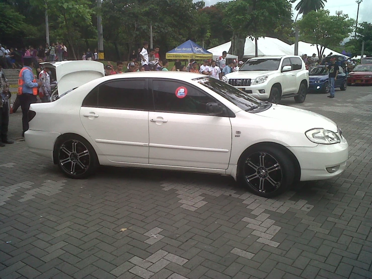 a white car is parked on the side of the road