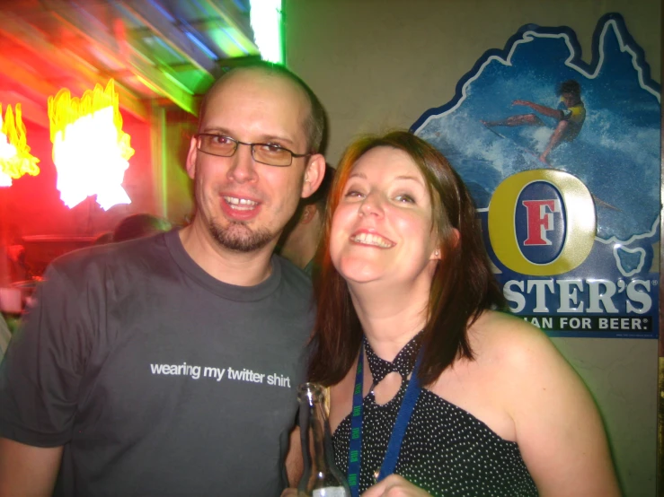 two people with beer in hand posing for the camera