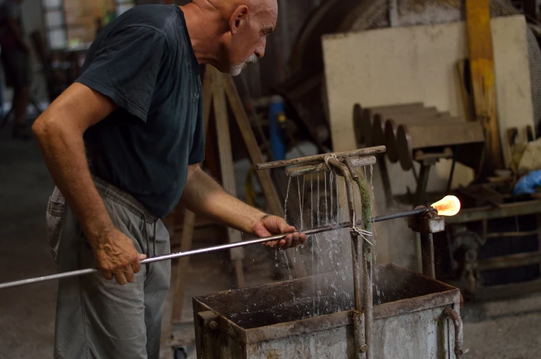 an old man operating a steel rod