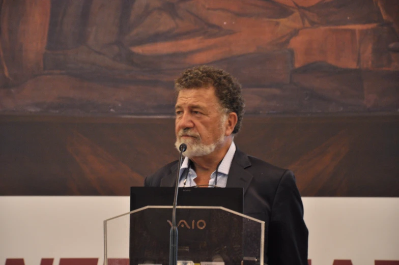 a man standing at a podium while making a speech