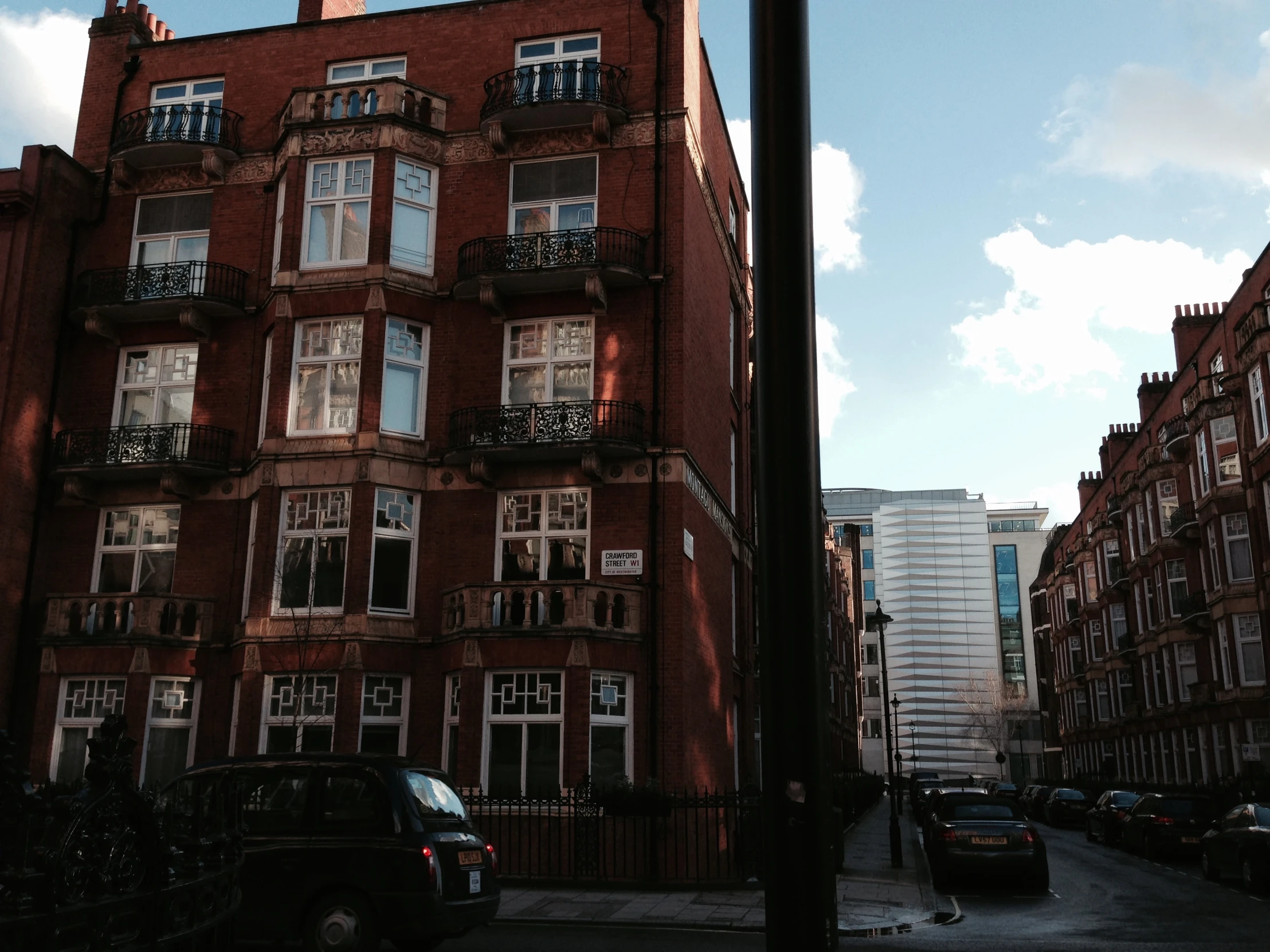 a big red building with multiple balconies near another building