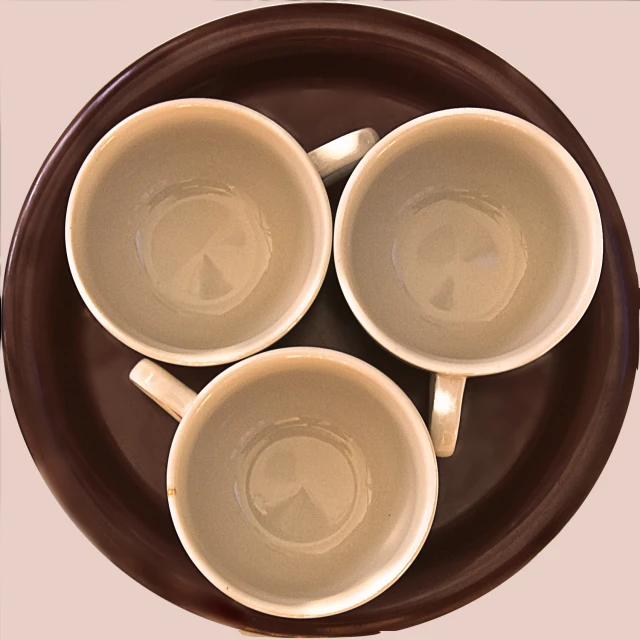 four coffee cups with spoons placed on a brown plate