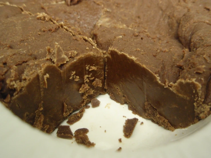 a white plate with pieces of chocolate cake and some sauce