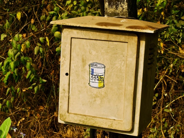 an old rusted box with a sticker sitting in front of it