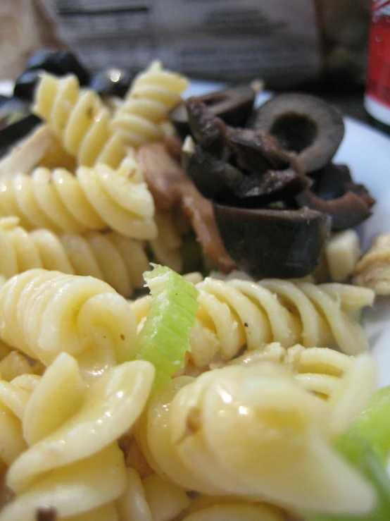 a white plate topped with pasta, mushrooms and broccoli