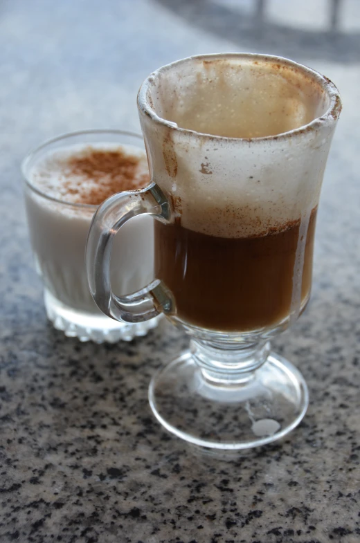 two drinks on a table are made with iced coffee