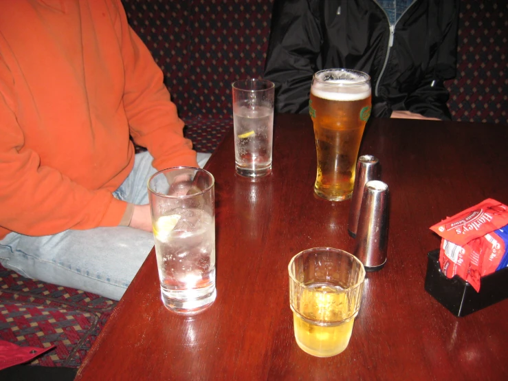 several glasses of beer sitting on a table with paper wrapped in a blue wrapping