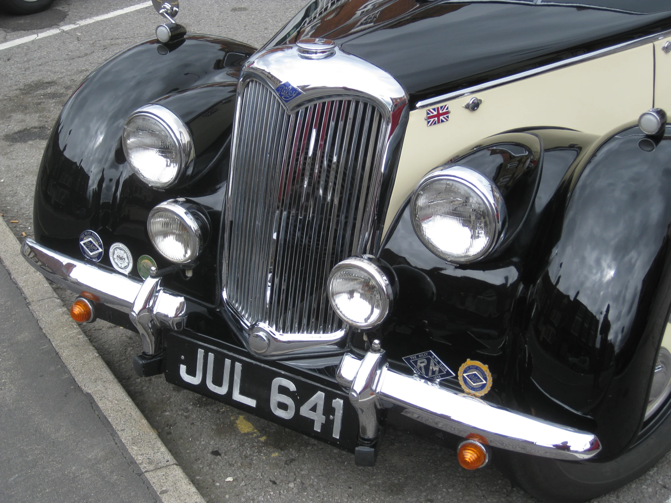 a vintage car sits parked in the street