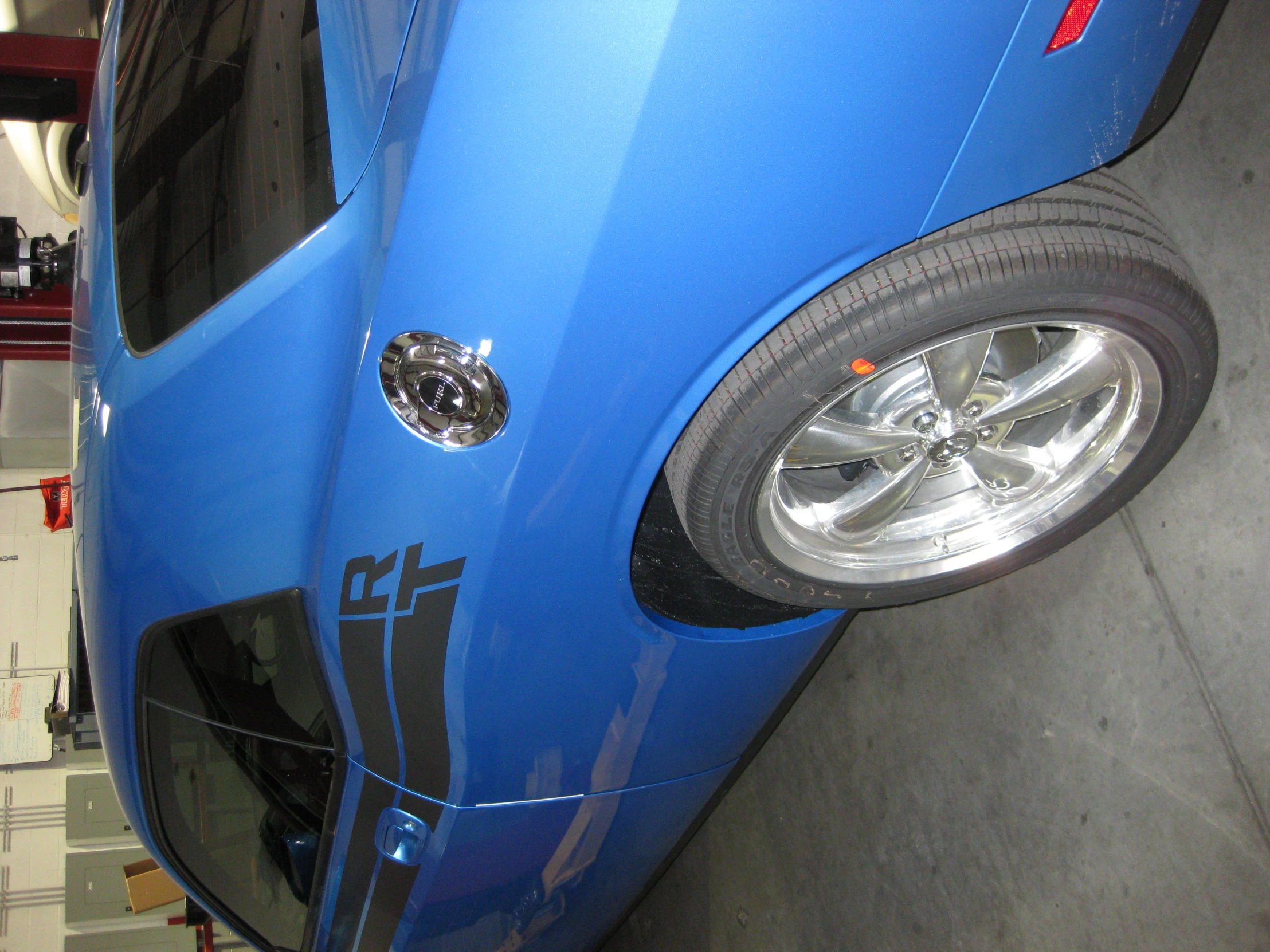 a very bright blue sports car in a garage