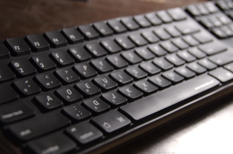 an apple keyboard on a desk with the top half removed