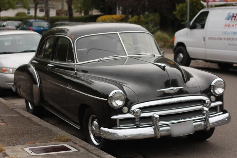 an old style car parked on the side of a road