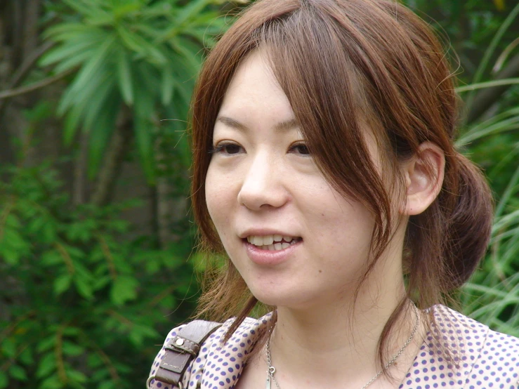 a woman standing next to the woods smiling