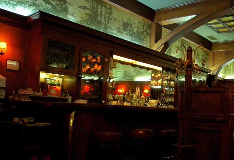 a bar area with two lighted shelves and bar stools