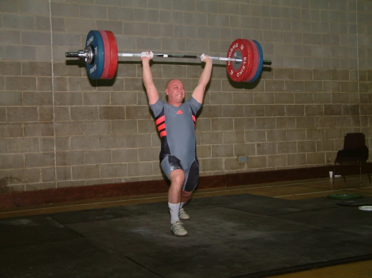 a man with a weight bar holds a large, heavy weight