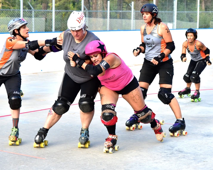 the four women are playing roller hockey on an outdoor field