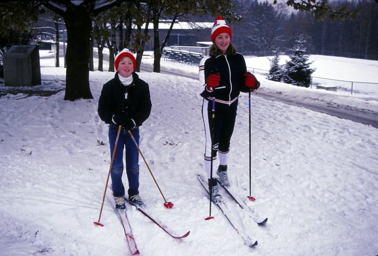 two little girls standing on skis in the snow