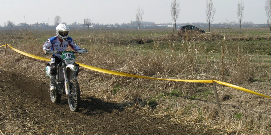 a man is riding his bicycle around a bend in the grass