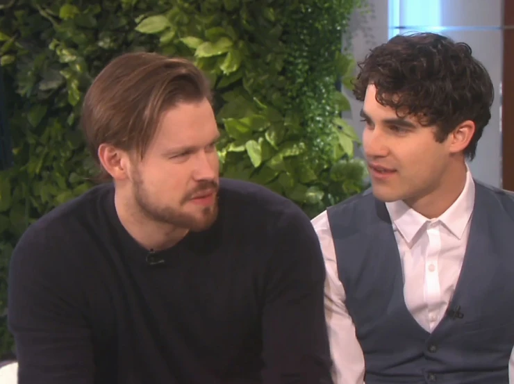 two young men having a conversation while sitting down