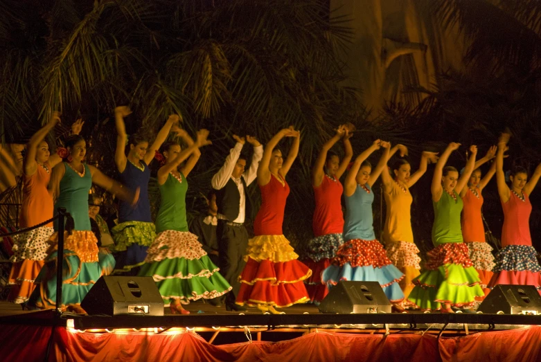 women in brightly colored dress performing at festival