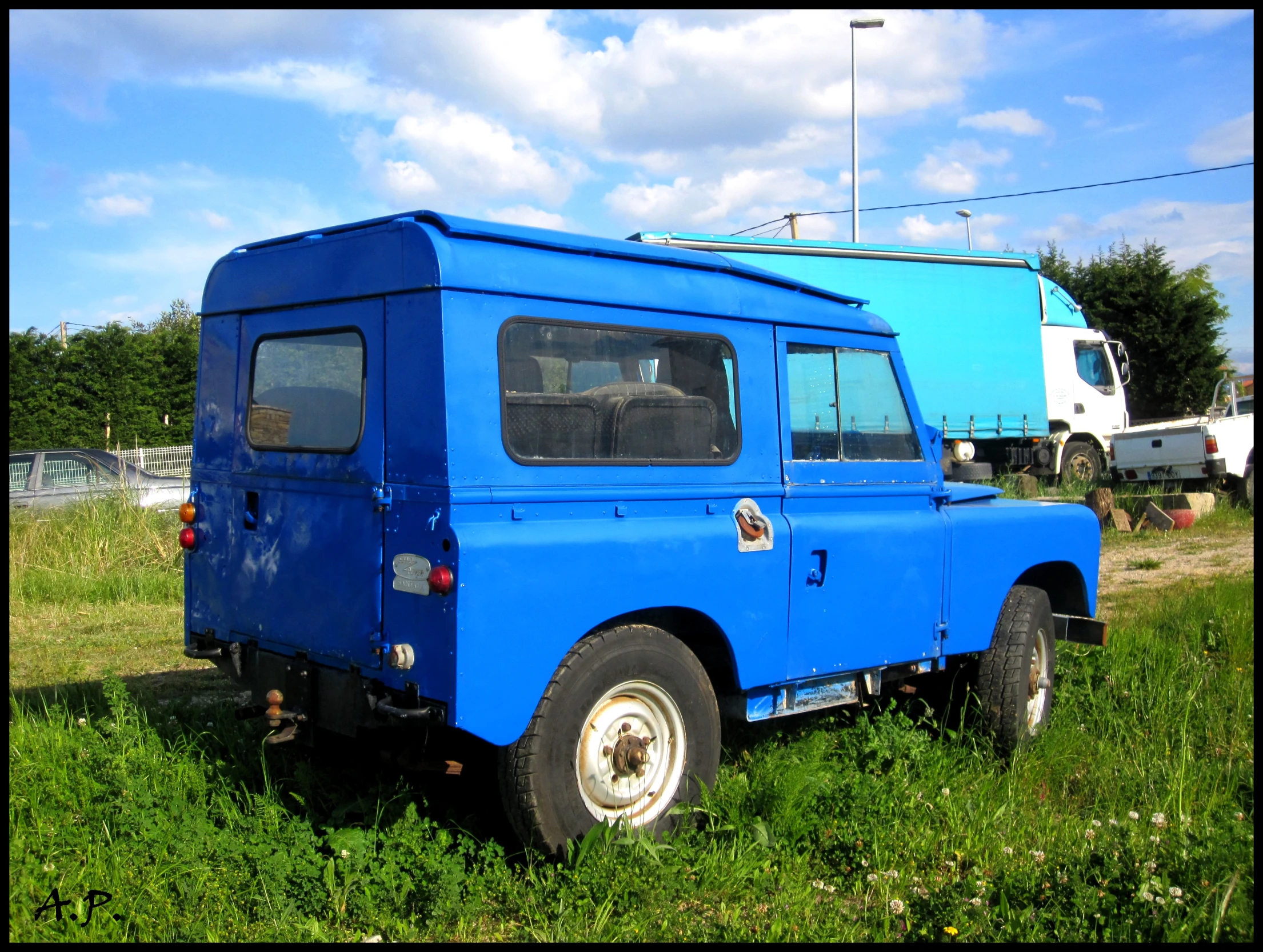 a blue truck in the middle of a field