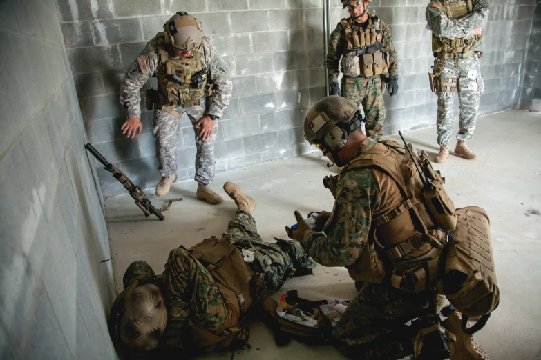 soldiers are setting on the floor in a warehouse