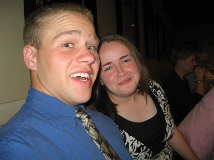 a man and woman standing together posing for the camera