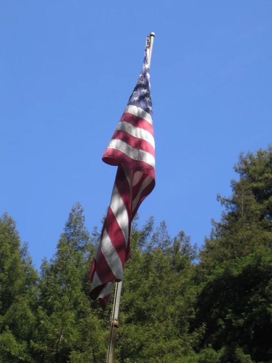 an american flag hanging from the top of a pole