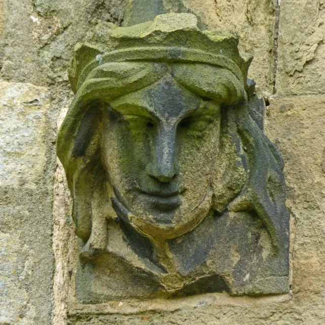 a stone head mounted to a rock wall