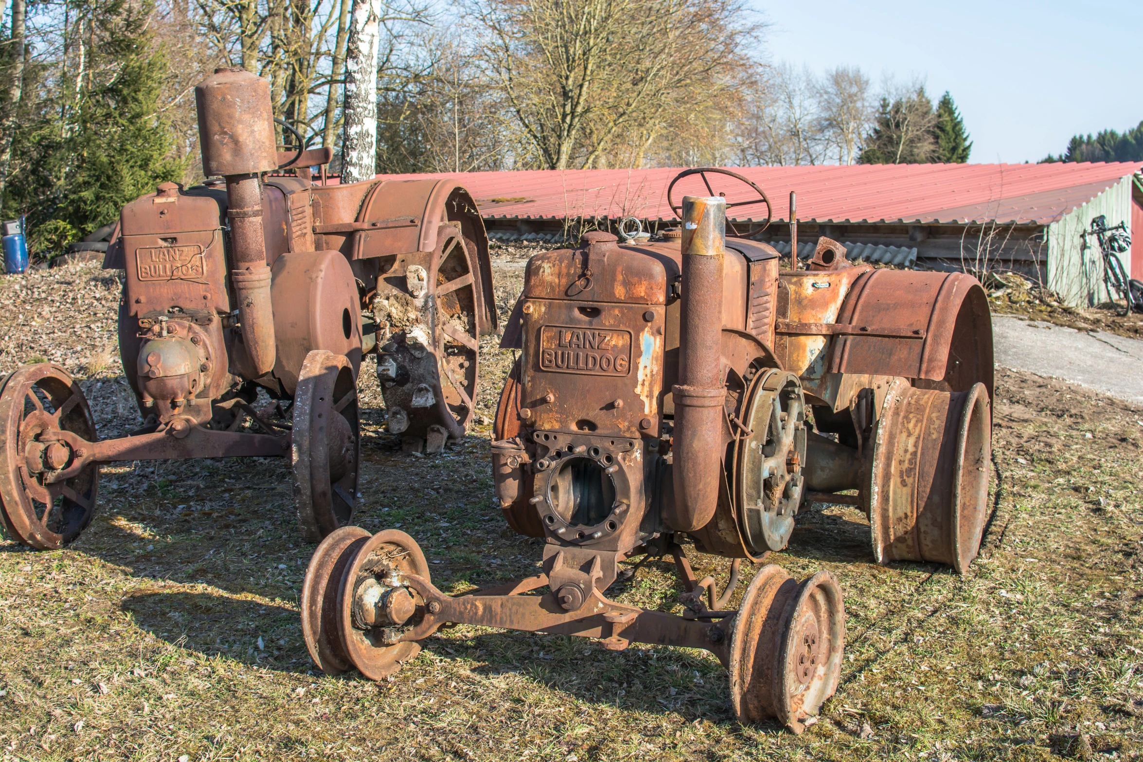 a set of rusty farm machinery sitting on top of grass