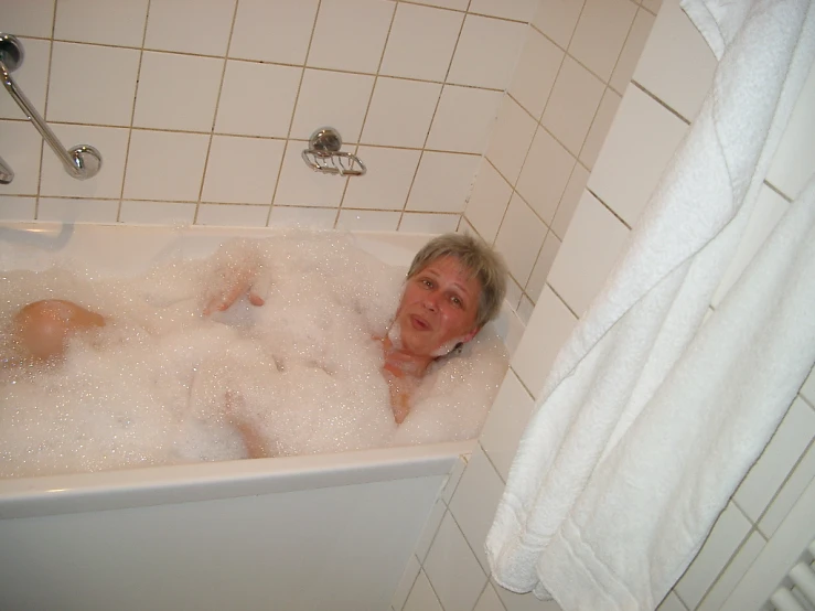 a woman relaxing in a bubble bath while holding her head up