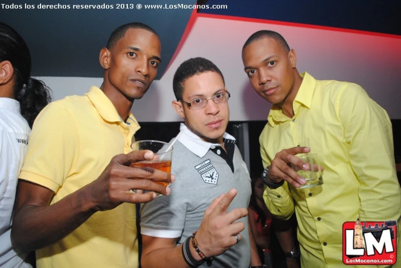 four young men are standing together and posing