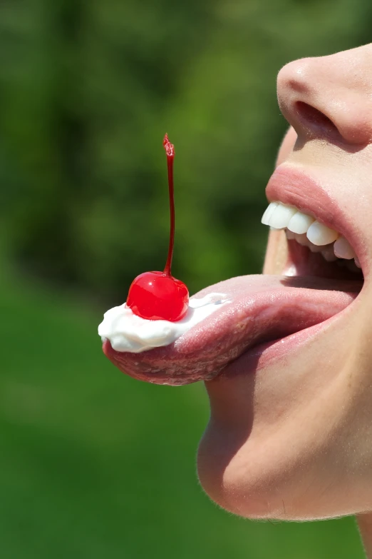 the woman is biting into the lip with a cherry on top