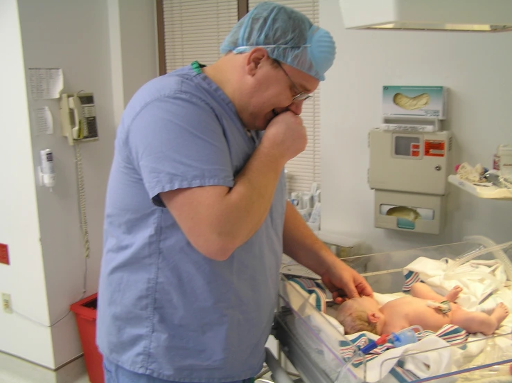 a male doctor examines a baby in the hospital