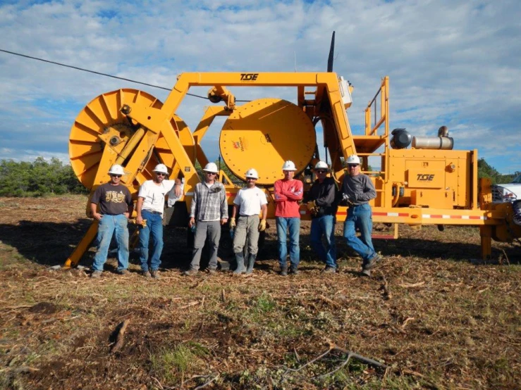 a group of people standing around a big tractor