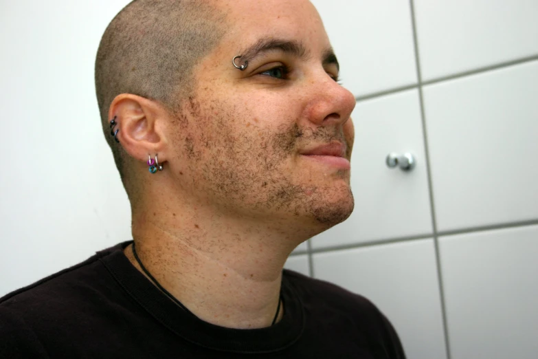 a man with a haircut that has small jewels on his forehead