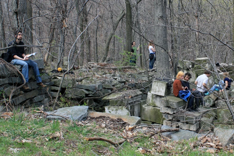 group of people playing instruments near a rock pile