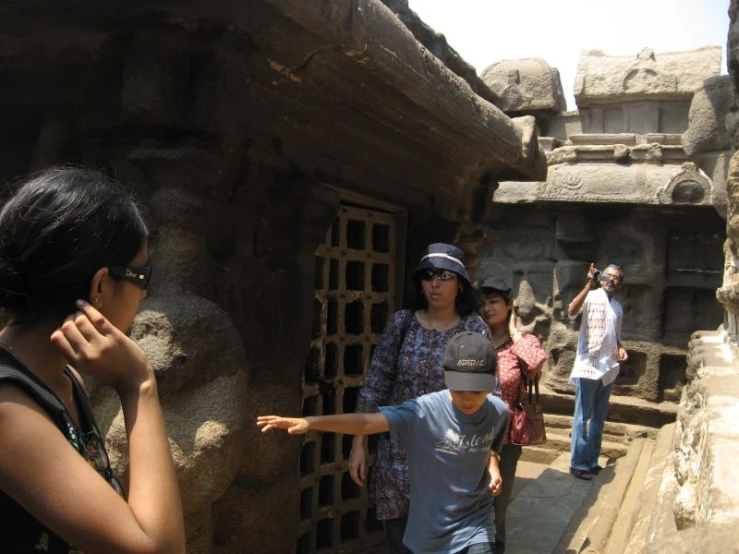 a young person in a baseball cap points at the walls on display