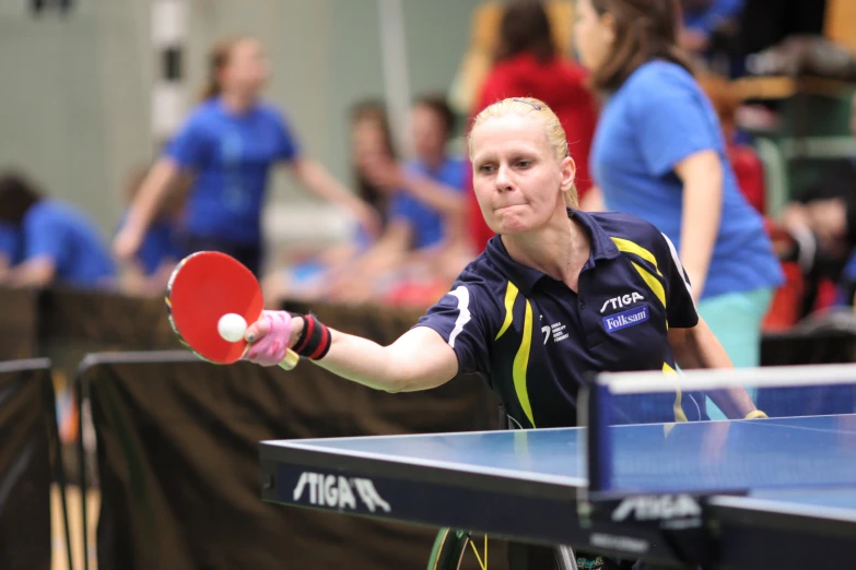 a woman in a game of table tennis with a ping pong paddle