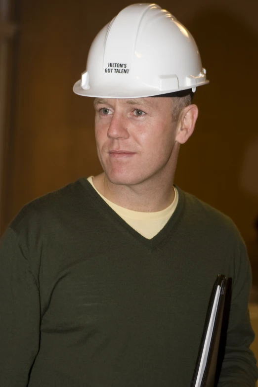 a man wearing a hard hat with a binder over his shoulder