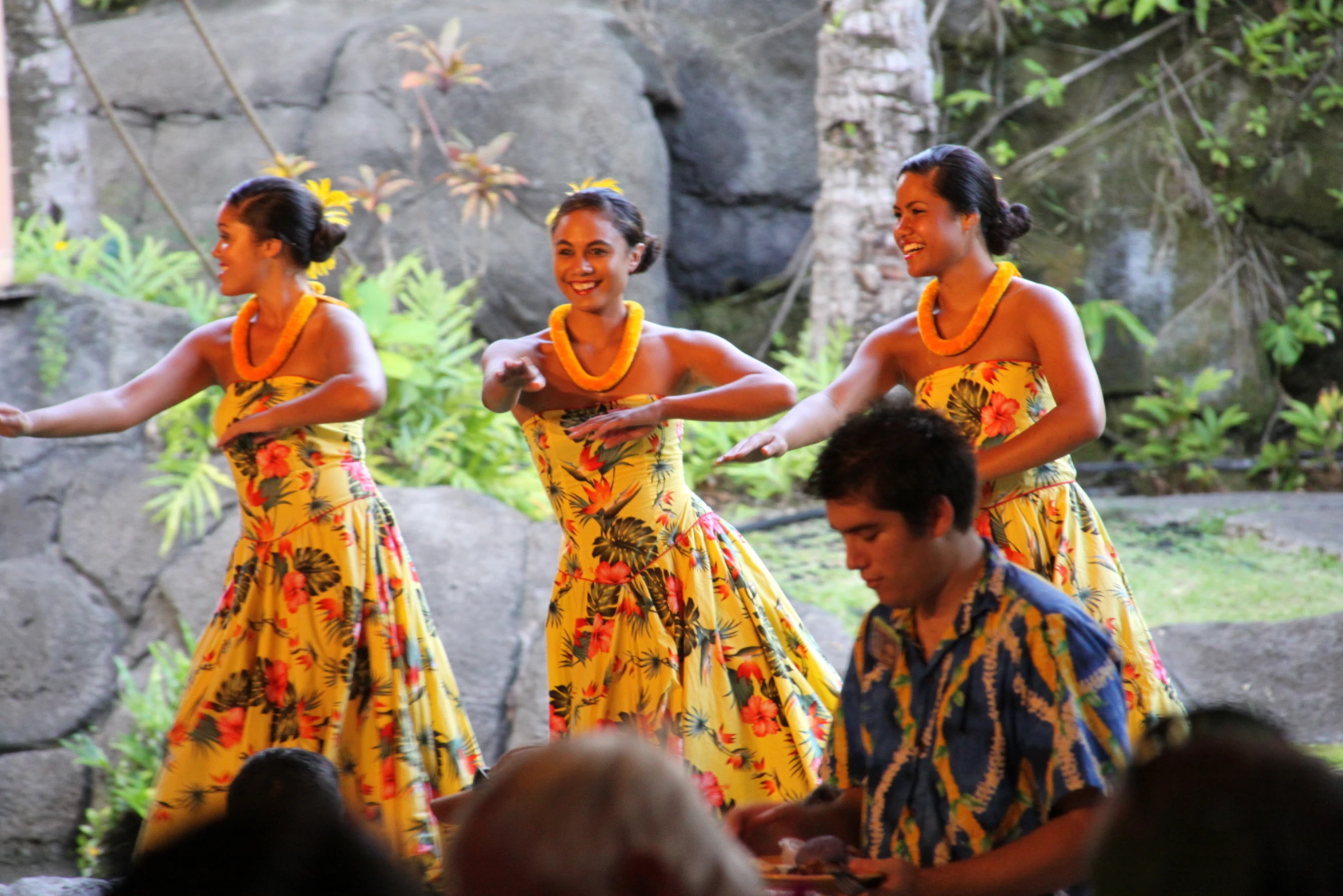 three people in yellow dress performing on stage