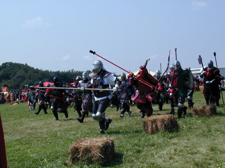 a large group of people dressed in knights on horses