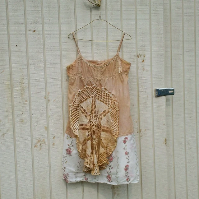 a tank top hanging on a wall next to an iron hook