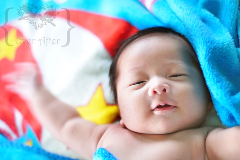 baby with eyes closed laying on a blanket