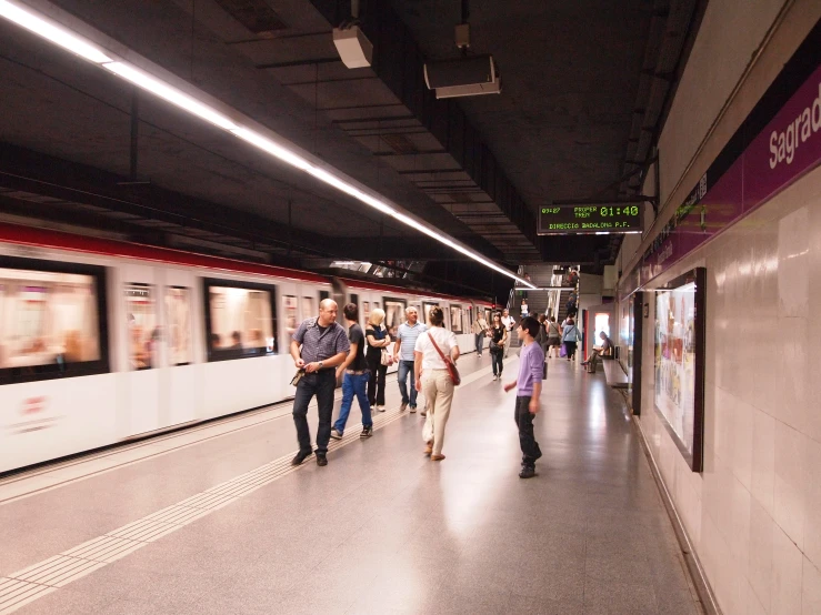 people waiting to board the subway at the train station