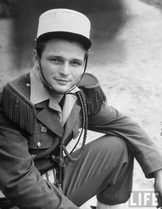 a man wearing a hat and boots posing for a picture