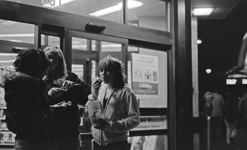 people stand in a public area while holding their phones